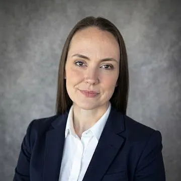 Amanda Cozar, a Washington eXp Realty broker, smiling in a navy blazer and white shirt